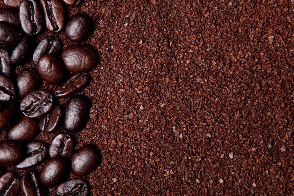 Whole coffee beans next to ground coffee