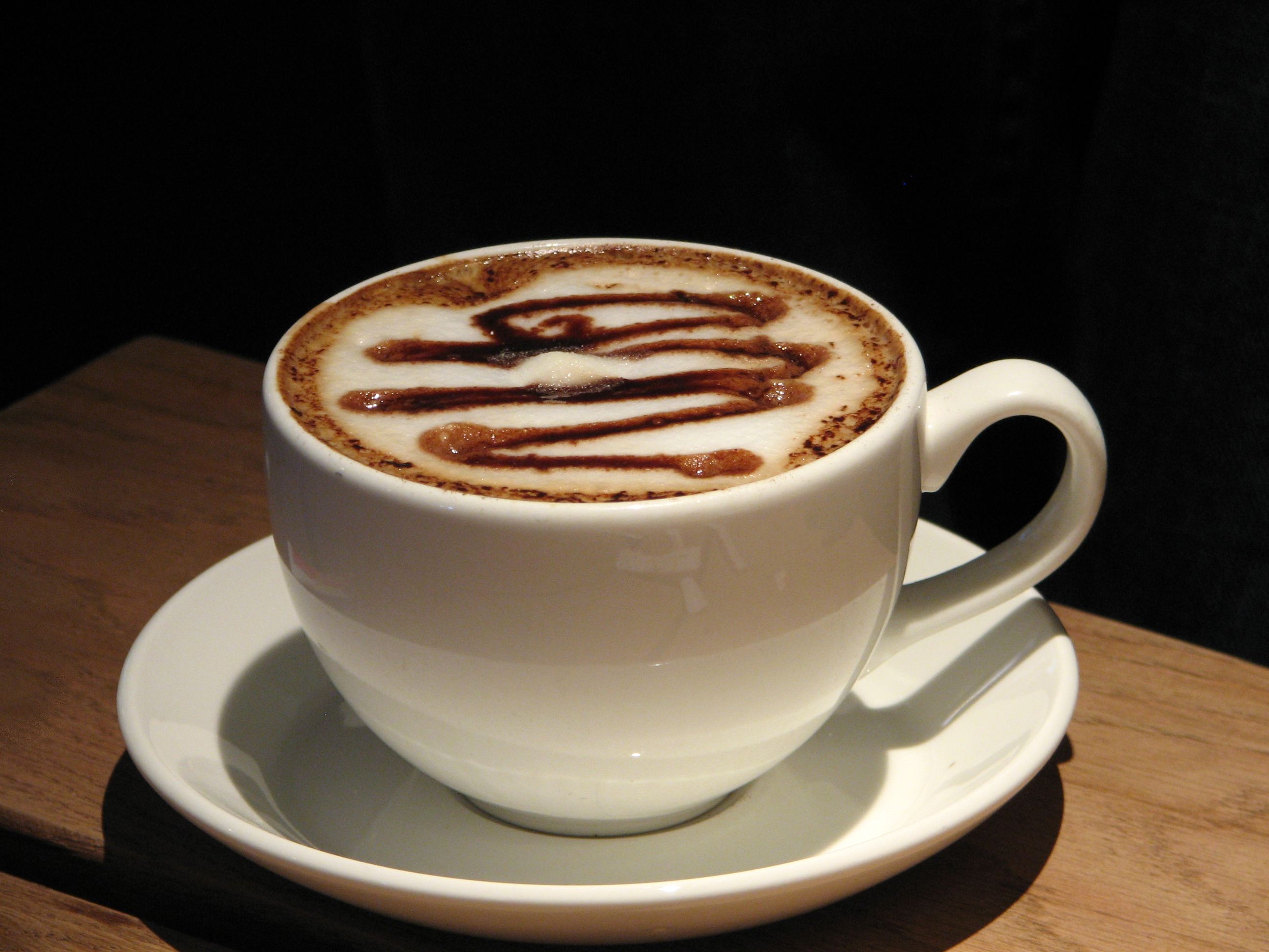 A close-up of a latte with caramel drizzle